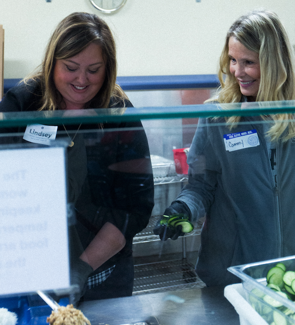 Lindsey Gobel and Cammie Corken serve up fresh meals to the homeless through LAVIDGE IPMACT.