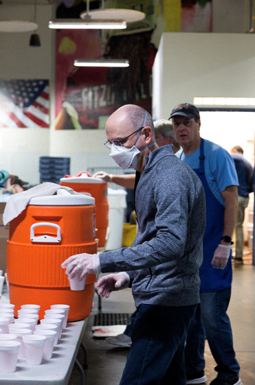 LAVIDGE Chief Innovation Officer Stephen Heitz keeps drink cups filled with punch for the lunch crowd at The Society of St. Vincent de Paul dining hall.