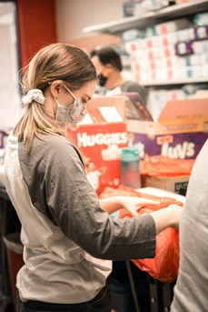 Hannah Coda sorts diapers as a volunteer for Harvest Compassion Center through LAVIDGE's IMPACT employee volunteer program.