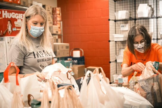 Anne Robertson, Managing Director, PR; and Laurie Schnebly, Senior Copywriter, sort food donations collected by LAVIDGE IMPACT volunteers for Harvest Compassion Center in May 2021.