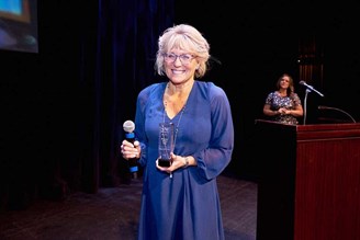 Betsey Griffin Jones smiles for the event photographer while accepting there Phoenix Ad Club's 2022 Phyllis Ehlinger Women of Excellence Award.